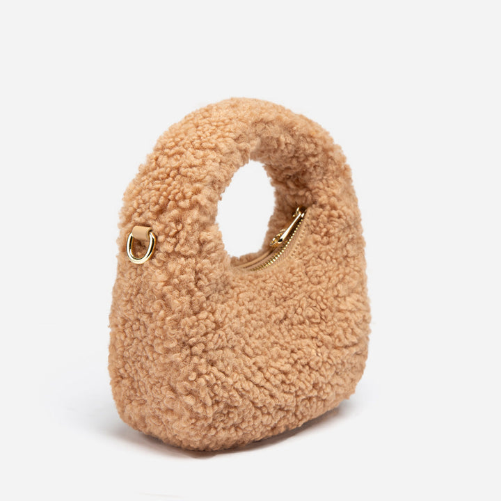 Beige shearling handbag with gold zipper on a white background