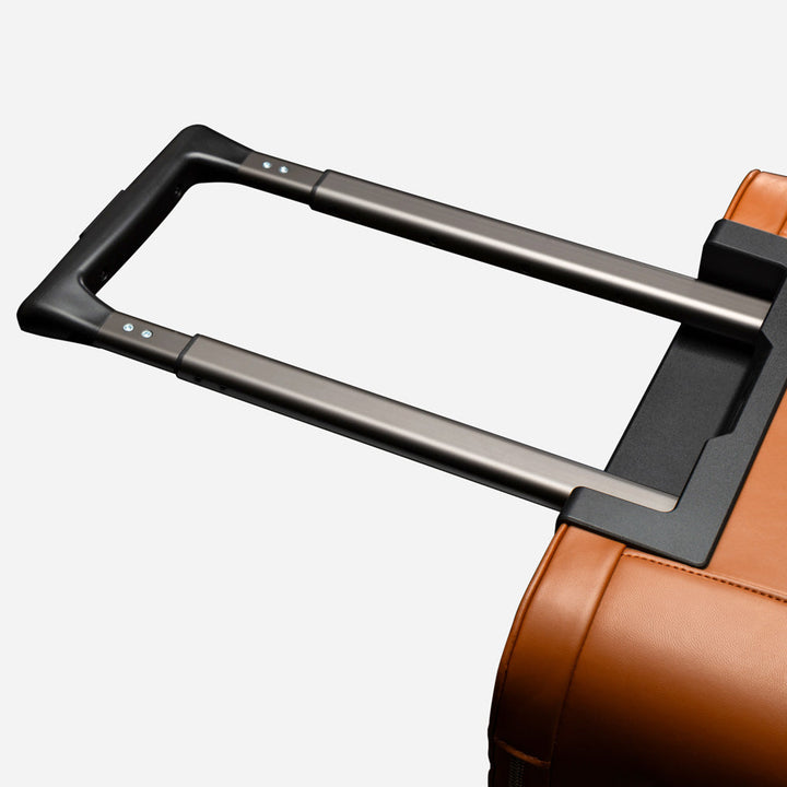 Close-up of a brown suitcase handle on a white background