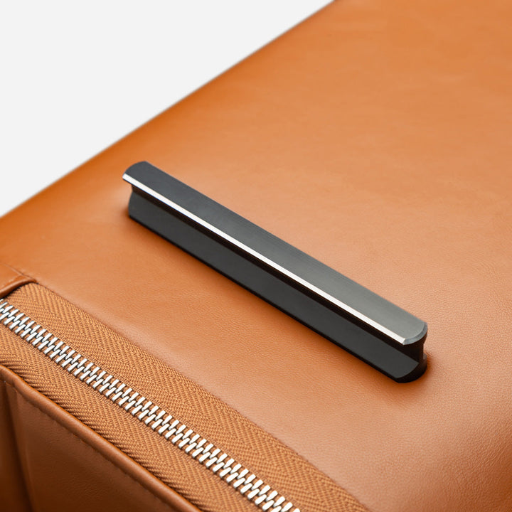 Close-up of a brown leather suitcase with a silver bottom stud